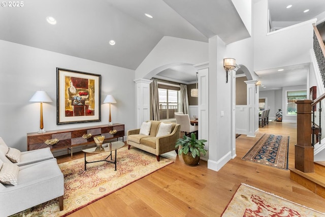 living area with arched walkways, hardwood / wood-style floors, and ornate columns