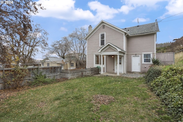 rear view of house featuring a lawn