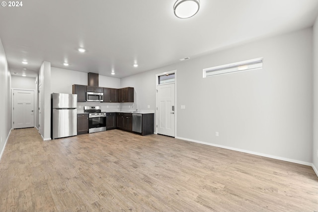 kitchen featuring light wood-type flooring, dark brown cabinetry, and appliances with stainless steel finishes