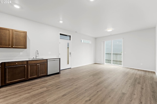 kitchen with sink, dishwasher, and light wood-type flooring