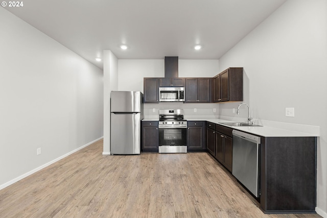 kitchen featuring sink, light wood-type flooring, dark brown cabinets, and appliances with stainless steel finishes