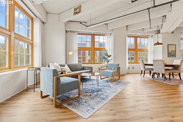 living area with light hardwood / wood-style floors, lofted ceiling with beams, and wooden ceiling