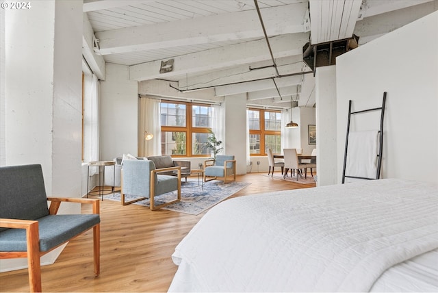 bedroom with hardwood / wood-style floors and beam ceiling