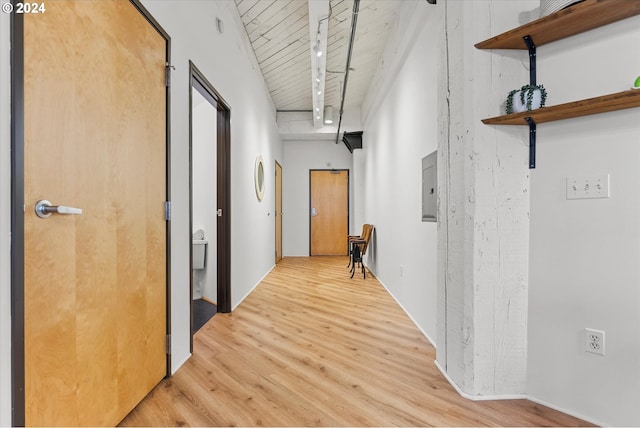 corridor featuring light wood-type flooring, electric panel, and wood ceiling