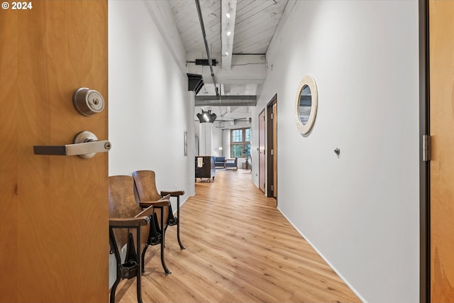 corridor with beam ceiling, wood ceiling, and light hardwood / wood-style flooring