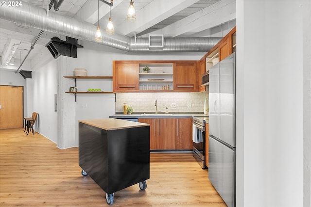 kitchen with sink, light hardwood / wood-style floors, hanging light fixtures, and appliances with stainless steel finishes