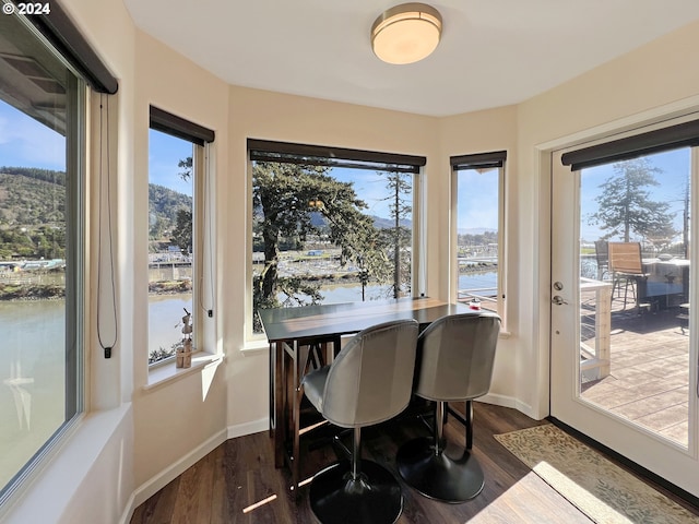 sunroom / solarium featuring a water view