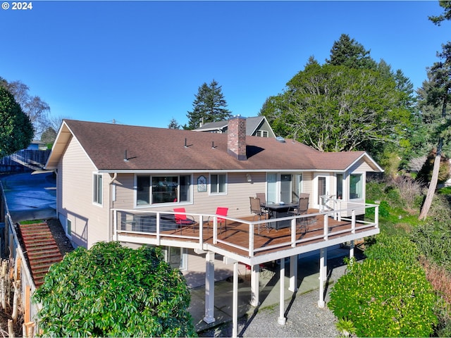 rear view of property with a wooden deck and a patio