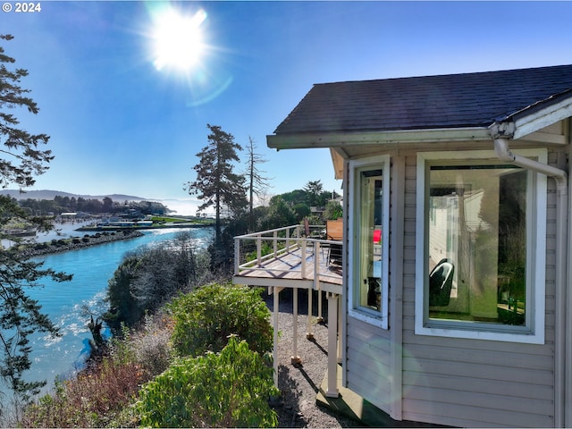 view of home's exterior featuring a deck with water view