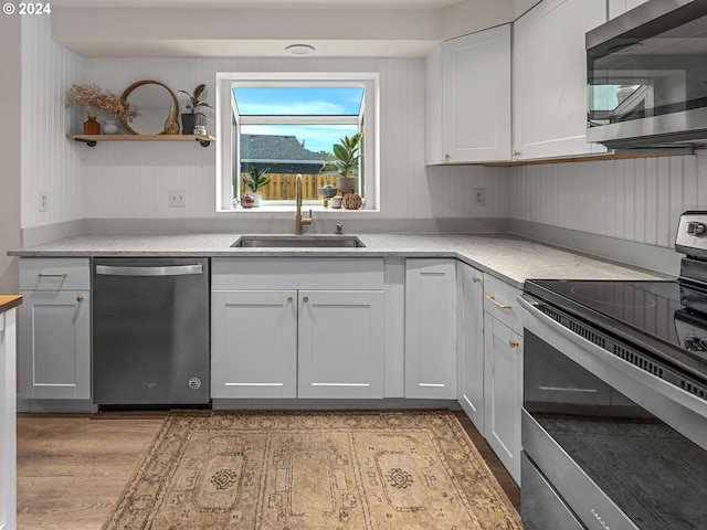 kitchen featuring white cabinetry, light hardwood / wood-style floors, appliances with stainless steel finishes, and sink