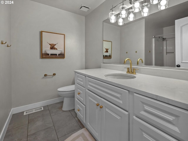 bathroom with a shower, vanity, toilet, and tile patterned floors