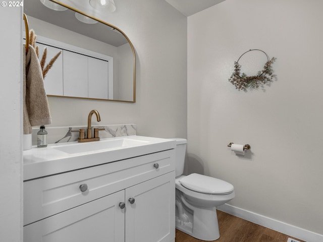 bathroom with hardwood / wood-style floors, vanity, and toilet