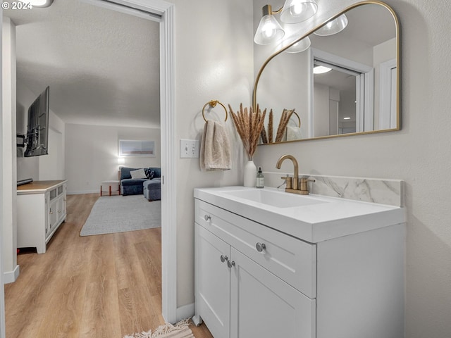 bathroom with a textured ceiling, vanity, and hardwood / wood-style floors