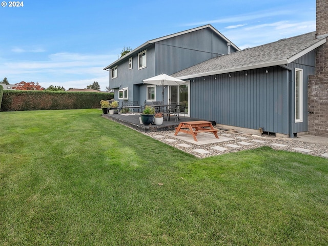 back of property with a yard and a patio area