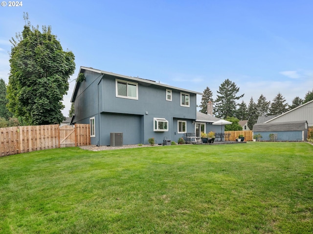 back of house with a yard and central AC