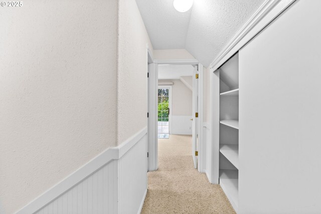 5213 Hilltop Dr, Florence, OR 97439 - corridor with vaulted ceiling, a textured ceiling, and light carpet