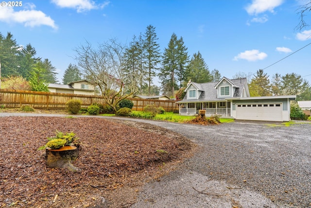 5213 Hilltop Dr, Florence, OR 97439 - view of front facade featuring fence, gravel driveway, and a garage