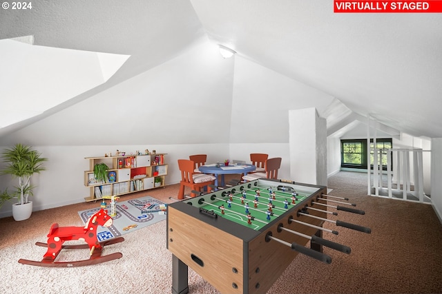 game room featuring vaulted ceiling, carpet, and a textured ceiling