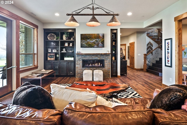 living room featuring a fireplace, dark hardwood / wood-style flooring, and built in features