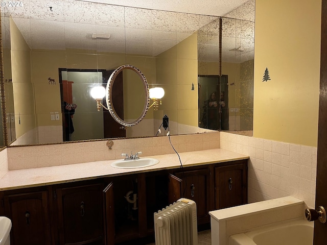 bathroom featuring a washtub, radiator heating unit, vanity, and tile walls