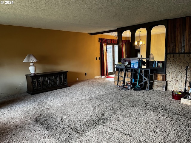 living room featuring carpet, a textured ceiling, and a chandelier