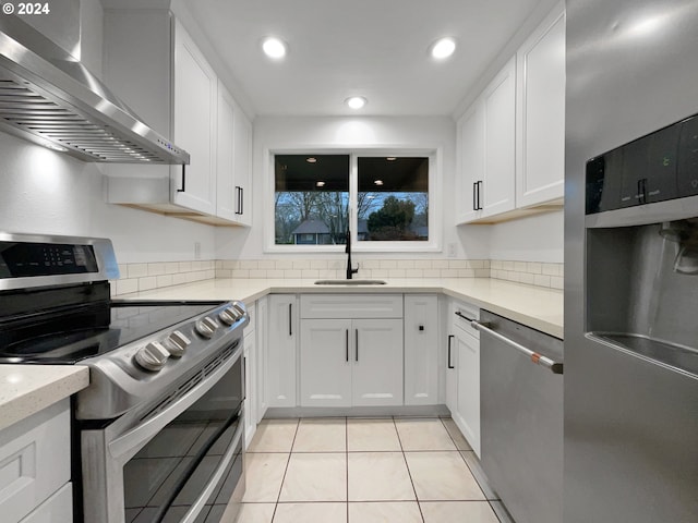 kitchen featuring white cabinetry, sink, wall chimney range hood, and appliances with stainless steel finishes