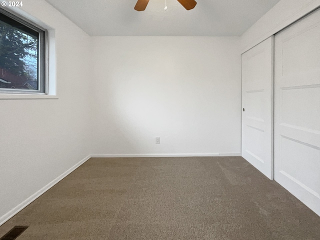 unfurnished bedroom with carpet, ceiling fan, and a closet