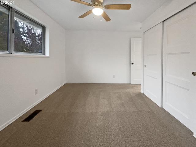 unfurnished bedroom with carpet flooring, ceiling fan, and a closet