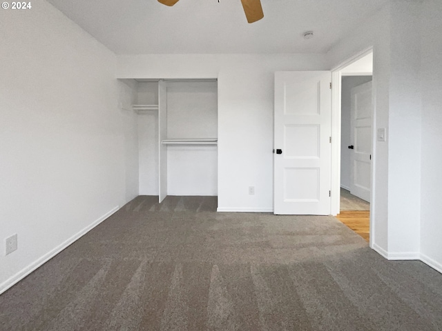 unfurnished bedroom with a closet, dark carpet, and ceiling fan