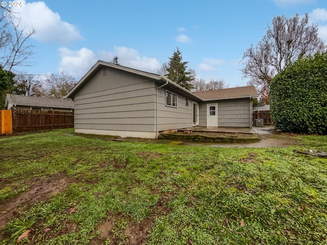 rear view of property featuring a patio area and a yard