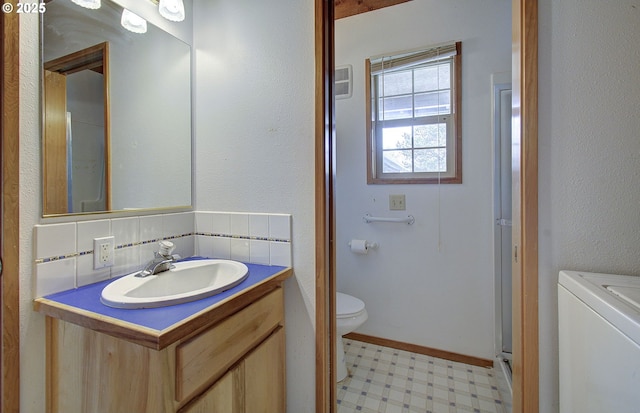 34540 Nestucca Blvd, Cloverdale, OR 97112 - bathroom with washer / dryer, tile patterned floors, vanity, toilet, and tasteful backsplash