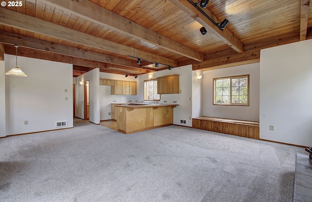34540 Nestucca Blvd, Cloverdale, OR 97112 - kitchen featuring open floor plan, wooden ceiling with exposed beams, a peninsula, light colored carpet, and baseboards