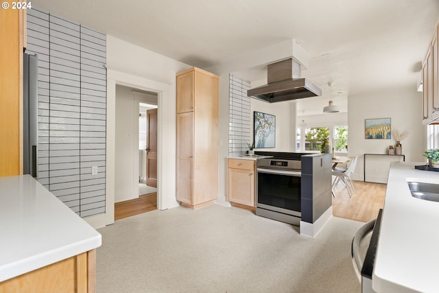 kitchen featuring island range hood, stainless steel range, light wood-type flooring, and light brown cabinetry