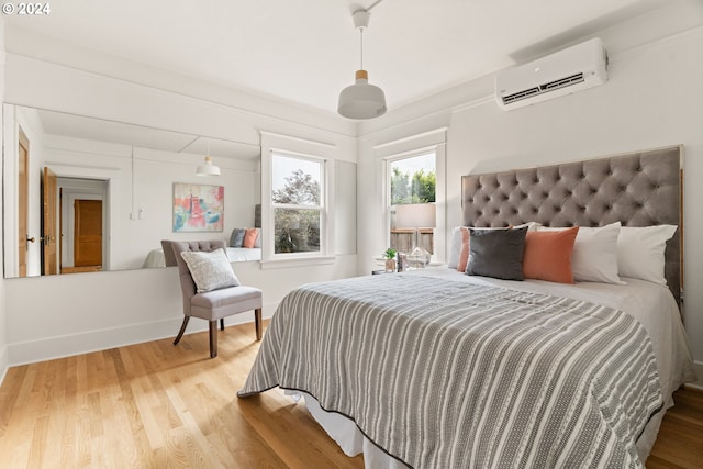 bedroom featuring an AC wall unit and hardwood / wood-style floors