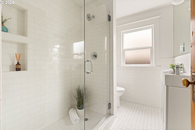 bathroom featuring tile patterned flooring, walk in shower, toilet, and tile walls