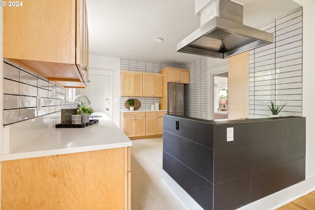 kitchen with light wood-type flooring, decorative backsplash, sink, island range hood, and light brown cabinetry