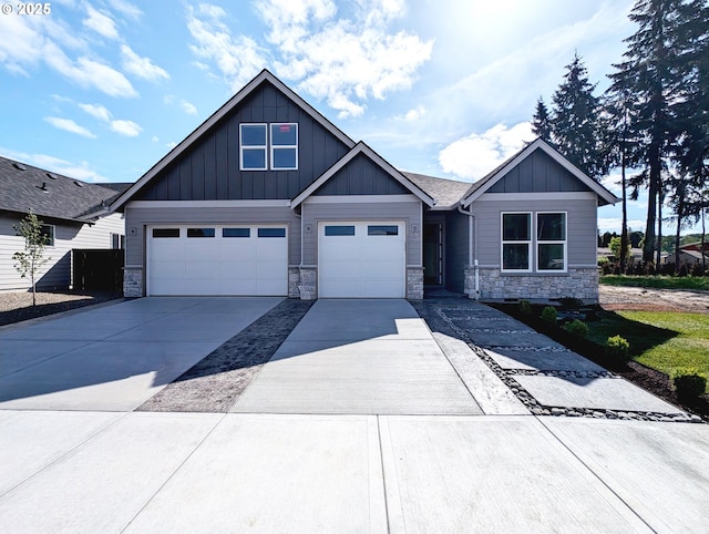 craftsman house featuring a garage, board and batten siding, stone siding, and concrete driveway
