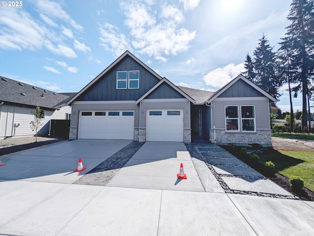 craftsman inspired home featuring board and batten siding, concrete driveway, and stone siding