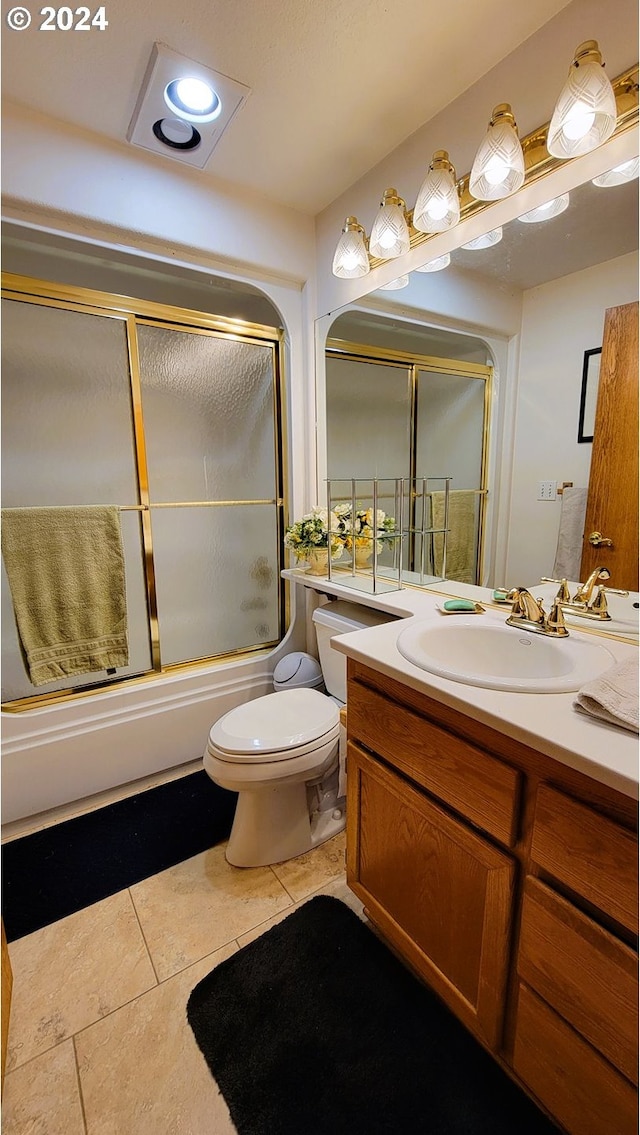 full bathroom featuring tile patterned flooring, vanity, toilet, and bath / shower combo with glass door