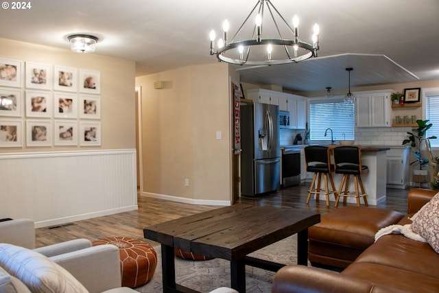 living room featuring hardwood / wood-style flooring, a notable chandelier, and sink