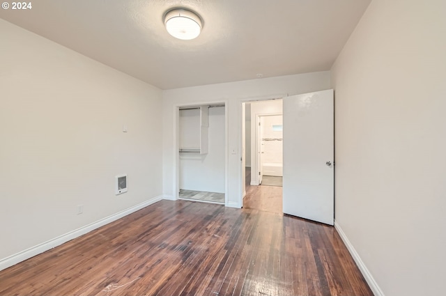 unfurnished bedroom with a closet and dark wood-type flooring