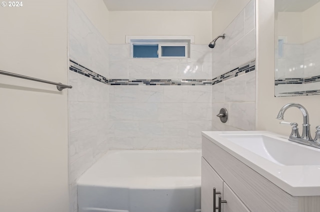 bathroom with tiled shower / bath and vanity