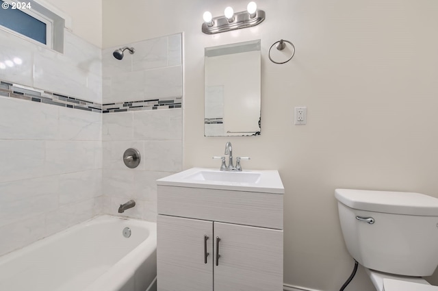 full bathroom featuring tiled shower / bath combo, vanity, and toilet