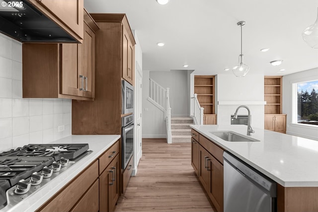 kitchen with pendant lighting, sink, appliances with stainless steel finishes, an island with sink, and custom exhaust hood