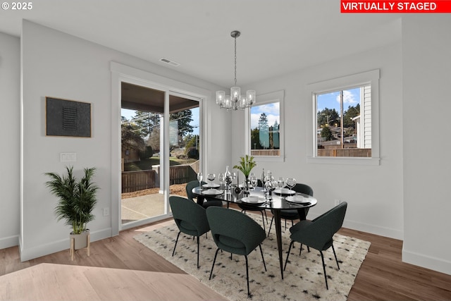 dining room with hardwood / wood-style flooring and an inviting chandelier