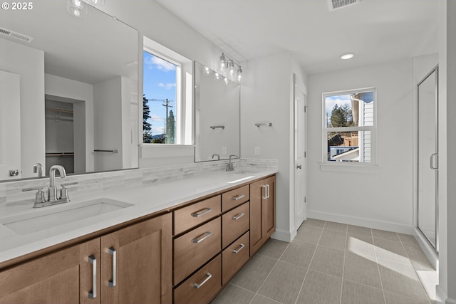 bathroom with walk in shower, tile patterned floors, vanity, and a wealth of natural light