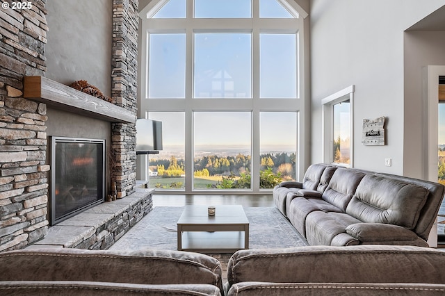 living area with a fireplace, a high ceiling, and a wealth of natural light