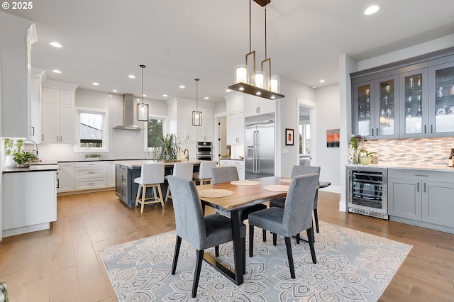 dining space featuring light wood-type flooring and beverage cooler