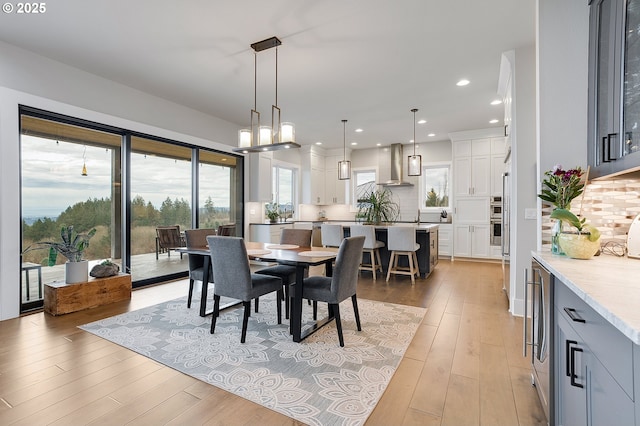dining area with recessed lighting and light wood-style flooring