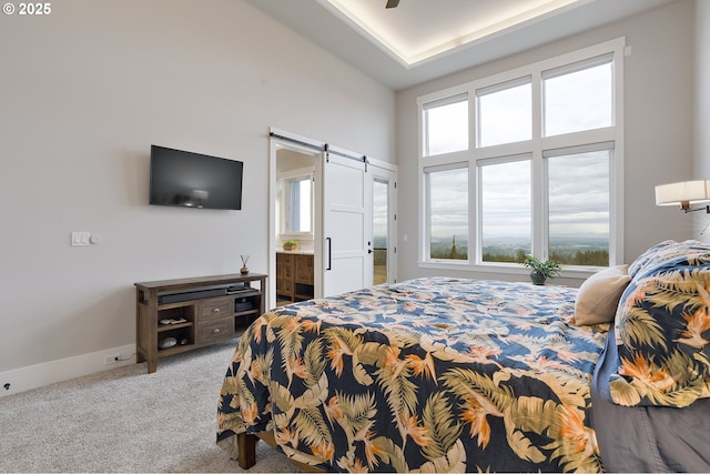 carpeted bedroom featuring lofted ceiling, connected bathroom, ceiling fan, and a barn door